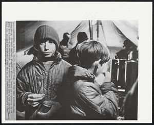 Chow Time in the Tent Kitchen -- Two youngsters, dressed against Alaska's winter, much on C-rations in an Army food center in Anchorage. The service and Red Cross are providing foor and shelter to stricken families of the earthquake damaged city.