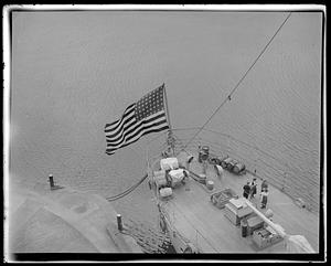 A flag flying from the deck of a ship