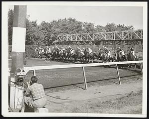 Jumping The Timer. New York, N.Y. -- The device at the left of this picture, taken today during the running of the first race at Belmont Park, starts the clock to time the race. The race is not timed from the moment the horses break, but from the time they pass before the photo-electric cell of this instrument. Thus the horses are allowed to get under way, or jump the clock, before the official timing starts.