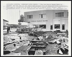 The new Wells Fargo Bank on Highway 101 was one of the first and hardest hit of Crescent City businesses. Wreckage in foreground is what is left of a nearby paint store. New Thunderbird Motel in left background was heavily damaged.
