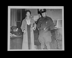 Woman holding flashlight next to man in uniform holding guns