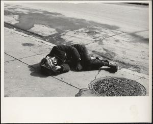Man lying on sidewalk, Boston