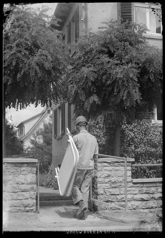 Military personnel carrying bed headboards, Waiblingen, Germany