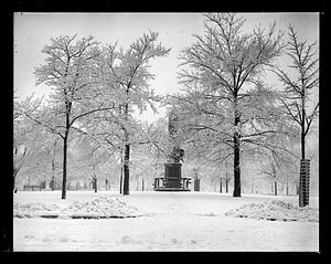 Snow covered trees, unidentified sculpture in background