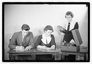 A man and a woman listening to a record, possibly taking a test