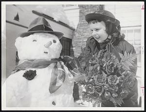 Springtime Snowman -- Mr. Snowman needs a flower to mark the first day of spring says five-year-old Patricia Ann Curtin playing outside here Arnold road, Stoneham, home yesterday. Flowers were borrowed from her mother. Two feet of snow that fell in past few days is biggest snowfall of Patricia’s life.