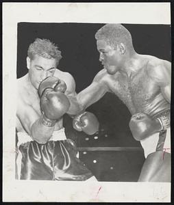 It Was Punches Like This that bloodied Rocky Marciano's face. Challenger Ezzard Charles is landing a right to the jaw in the seventh round of the Yankee Stadium bout.