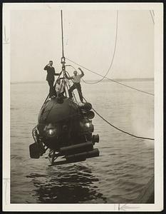 Testing Out the New "Cannon Ball" Diving Bell. This new diving bell invented by W. D. Sisson, an American engineer, is being tested in Long Island Sound at New Rochelle. The Diving Bell is a Giant Sphere eight feet in diameter. The shell is of tough Vanadium steel, 1 1/4 inches in thickness, and weighs with the machinery inside, 6 tons. Two operators form the crew of the diving bell, and the air supply will last for 72 hours / On the front are huge magnets which draw the ball to the hull of the sunken ship.