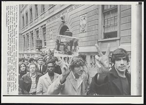 Protest Trial--Supporters of nine pacifists charged with burning draft board records last May marched outside the Post Office building Monday. Inside, the nine went on trial in U.S. District Court. Some 2,000 persons marched three miles through town and held a rally before moving to the Post Office building.