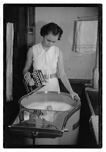 A woman doing laundry with a washing machine