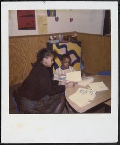 Woman and boy reading at a table