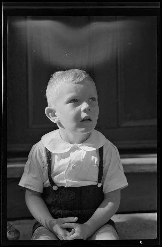 Boy on porch steps, looking up