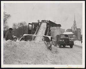 Into the Maw of a gigantic snowloader on Tremont street goes the streetside banks left by plows. Downtown section will be well cleared today but there will still be plenty of snow beside walks.