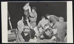 Women, Children Need Help as they climb over rail onto ship’s deck. In top photo Jewish woman is aided by fellow passenger. In lower photo Italian captain of “Al Tafchidunu” lifts infant over rail.