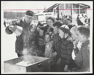 Mouth-Watering - Gov. Joseph B. Johnson of Vermont tests hot syrup to see if it is ready for sugar on snow while a group of young skiers wait at Stowe, Vt. The governor attended the party that ended the second annual Maple Week, which is designed to publicize the state's famed maple sugar and syrup.