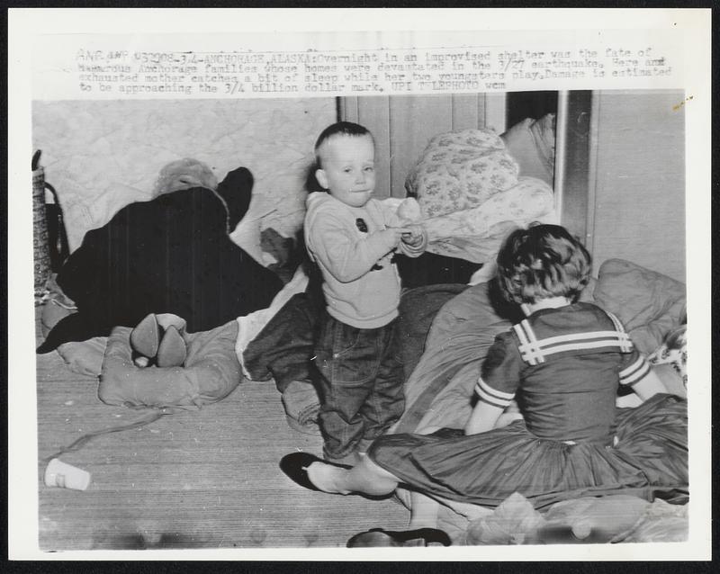 Overnight in an improvised shelter was the fate of numerous Anchorage families whose homes were devastated in the 3/27 earthquake. Here and exhausted mother catches a bit of sleep while her two youngsters play. Damage is estimated to be approaching the 3/4 billion dollar mark.