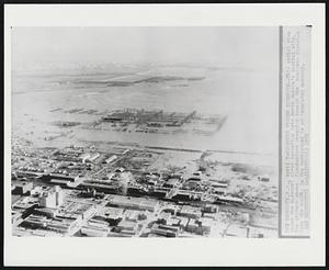 Missouri Floods Bismarck -- This aerial view shows the Missouri river spreading into North Dakota's capital city. The picture shows floodwaters creeping toward the business district from the south. In the background is an inundated nursery.