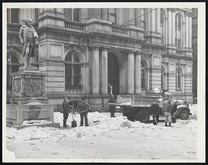 Snow being shoveled onto a truck next Benjamin Franklin statue, Boston