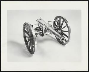 Late 19th Century Cannon, a British memento in collection owned by Frank Winthrop of Dedham. Carriage and cannon are silver, spokes and wheels, brass; and rim around outside of wheels, silver.