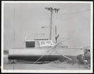 Boats in Trouble-The Nora M., of South Dartmouth, above, rests on wreckage from the bridge between South Dartmouth and Badanaram, while, below, the cruiser "Sachet" sits across a road in South Dartmouth as telephone linemen work on a pole in the background.