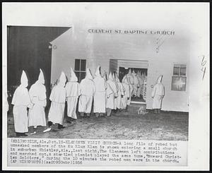 Klansmen Visit Church-A long file of robed but unmasked members of the Ku Klux Klan is shown entering a small church in suburban Whistler, Ala., last night. The Klansmen left contributions and marched out. A startled pianist played the same tune, "Onward Christian Soldiers," during the 10 minutes the robed men were in the church.
