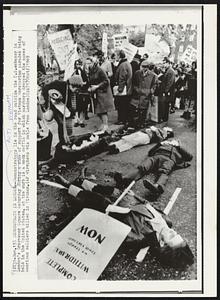 Demonstrate in London -- Demonstrators lie in the road outside the U.S. embassy in London's Grosvenor Square Saturday during a show of support for Vietnam Moratorium parades being held in the United States. At the curb is a mock coffin in which marchers dropped the names of American soldiers killed in Vietnam.