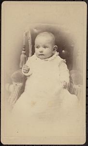 Portrait of a baby on a chair with tassels