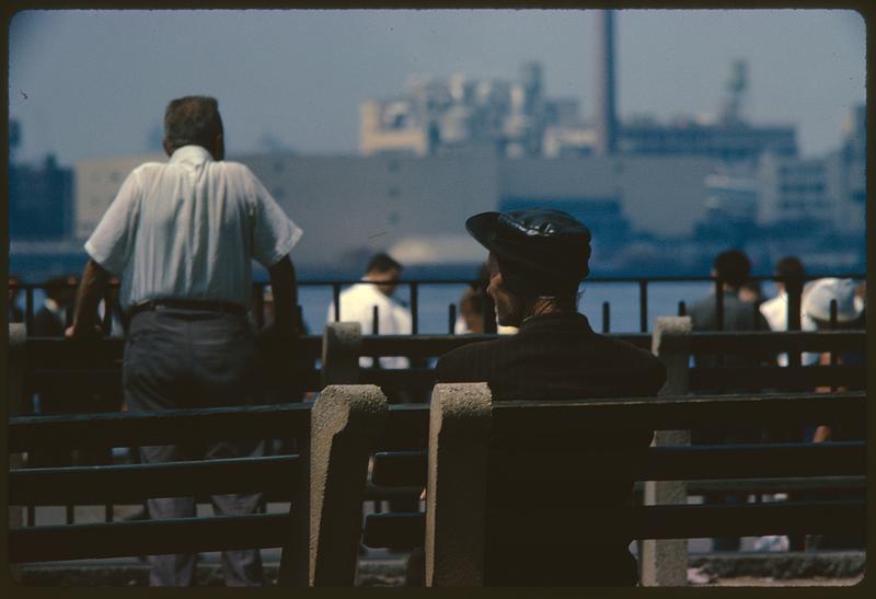 View from behind of man sitting on bench, likely New York