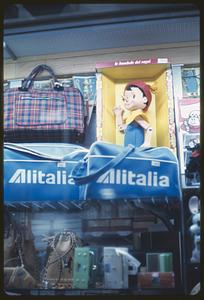 Merchandise display with Pinocchio doll and luggage, likely Rome