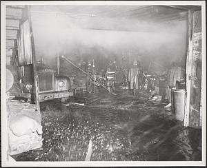 Fire fighters inspect smoke-filled and flooded interior, Boston