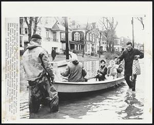 Safe and Dry--Fred Shaw, right, carries shopping bag of food as rescue workers pulls boat to shore with the rest of his family. Shaw family was removed from their home on the lower part of flooding Wheeling Island today as the Ohio River headed for a 46-foot crest, ten foot over flood stage.