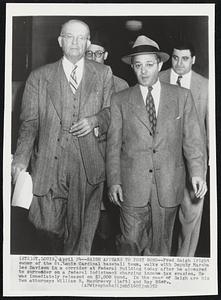 Saigh Appears to Post Bond -- Fred Saigh (right owner of the St. Louis Cardinal baseball team, walks with Deputy Marsha Les Davison in a corridor at Federal Building today after he appeared to surrender on a federal indictment charging income tax evasion. He was immediately released in $2,000 bond. In the rear of Saigh are his two attorneys William R. MacGreevy (left) and Ray Eder..