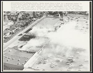 Smoke pours from a fire in a shopping center in Sylmar, Calif., about 30 miles north of Los Angeles that was caused by leaking natural gas lines that were ruptured by a giant earthquake that hit the Southern California area early 2/9. A large area north of Los Angeles was the hardest hit areas in the earthquake, with at least seven persons reported dead.