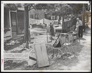 Fine Way to Treat Visitors-Southern visitors hit by Hurricane Carol dry out their belongings at their storm flooded cottage in Onset. The visitors are Mr. and Mrs. Louis Braverman of Miami Beach.