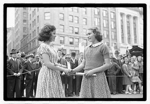 Two young women shaking hands