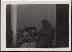 A woman sitting at a table and preparing food
