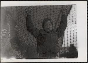 Brian Rezendes and Kymio Postell climbing on a fence
