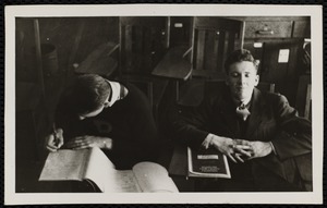 Two young men taking exam in classroom