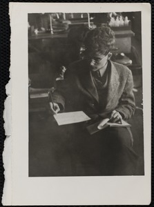 Unidentified student writing at a desk