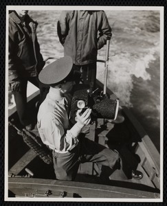 Soldier with large camera in whale boat