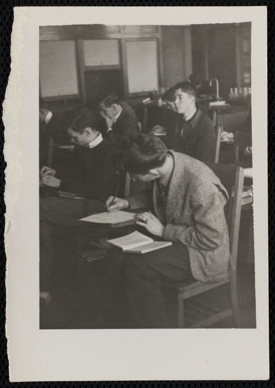 Male students writing at desks - Digital Commonwealth