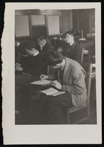 Male students writing at desks