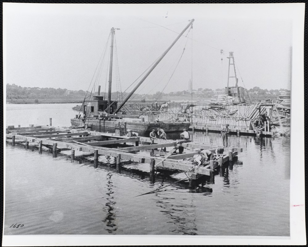 Men in a harbor, working on a pier