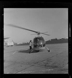 Woman entering a helicopter with pilot inside