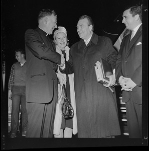 Red Skelton shaking hands with a clergyman
