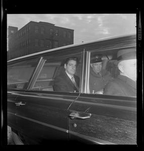 Albert DeSalvo in the backseat of car with a guard