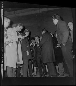 F. Lee Bailey, criminal defense attorney, talking with a few reporters as another journalist takes notes