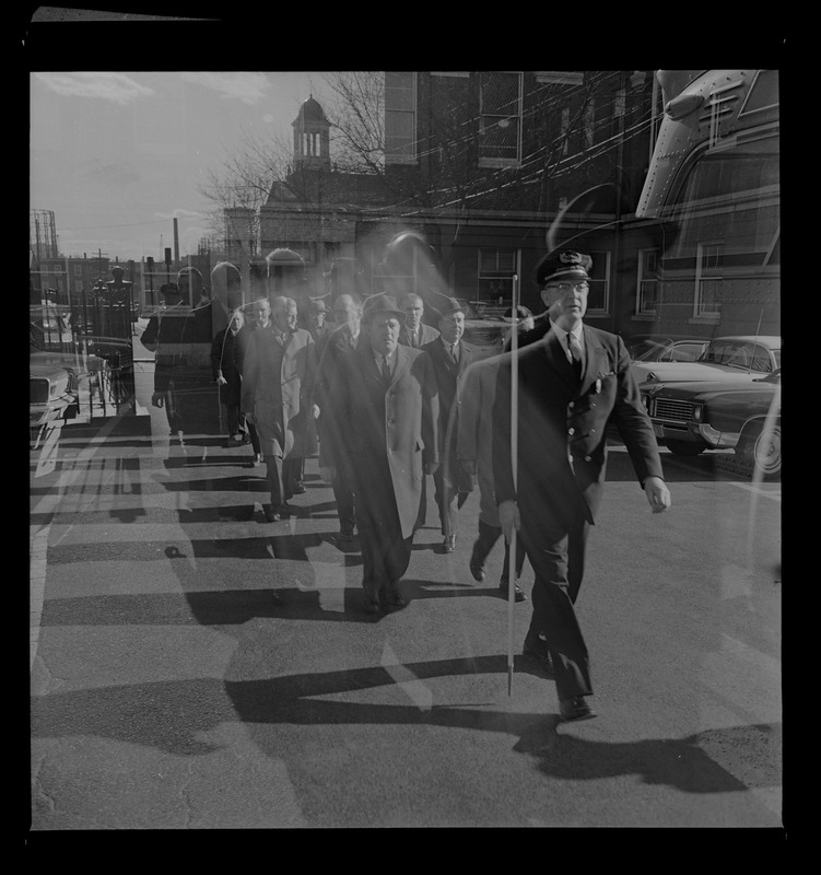 Jury crossing the street led by a bailiff