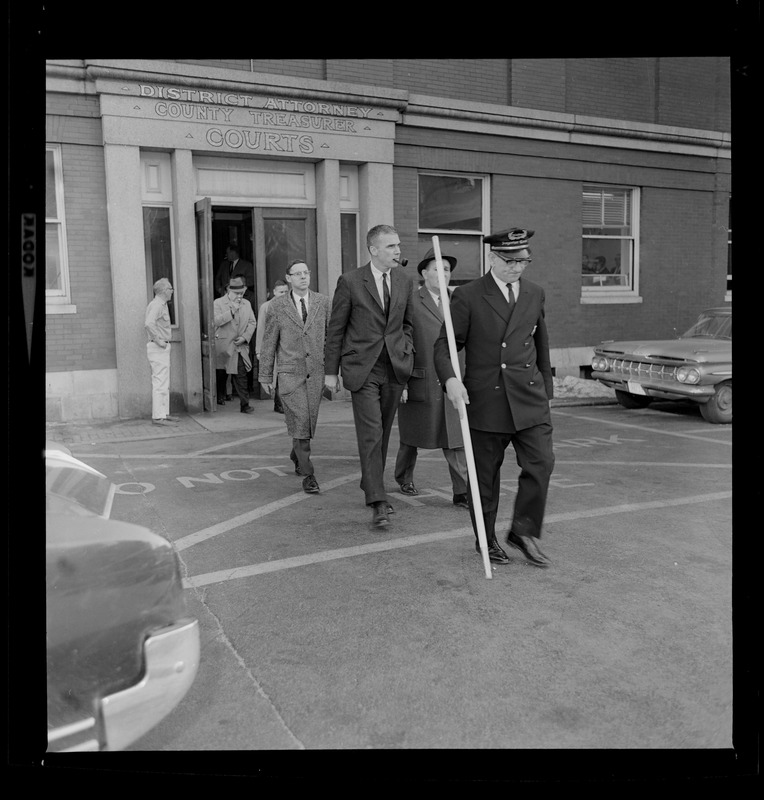 Jury walking out of courthouse with bailiff