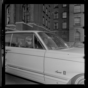 F. Lee Bailey and his wife, wearing sunglasses, sitting in a car
